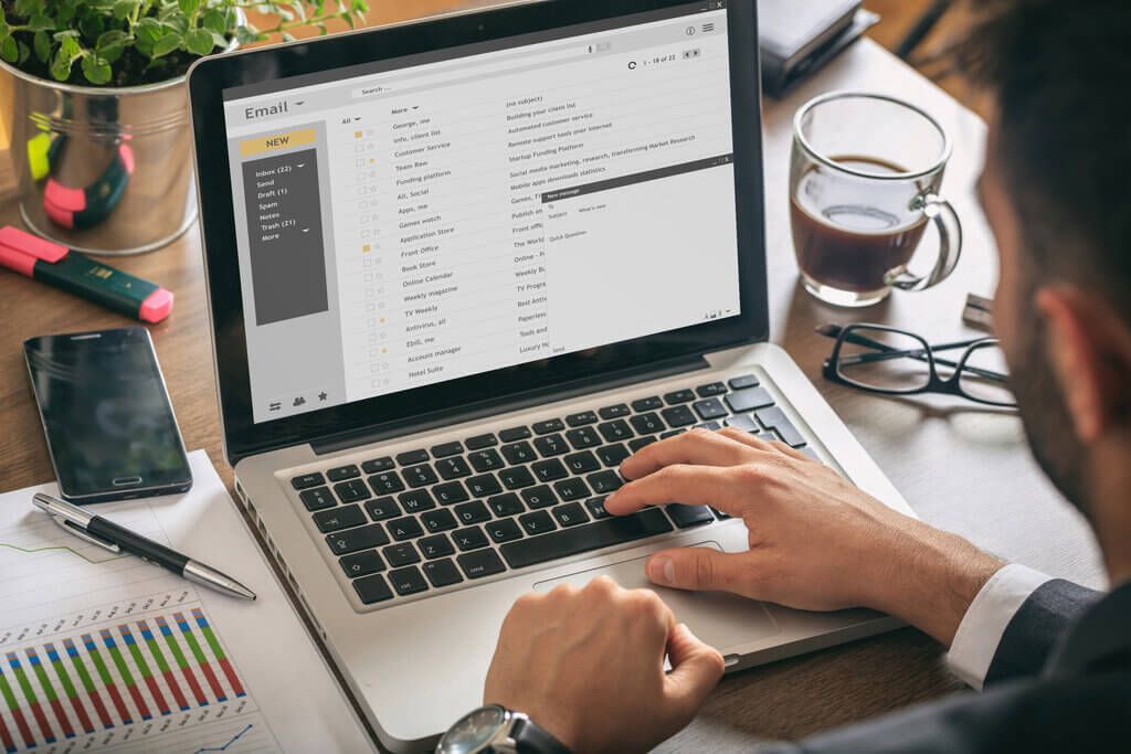 man checking email marketing software on laptop