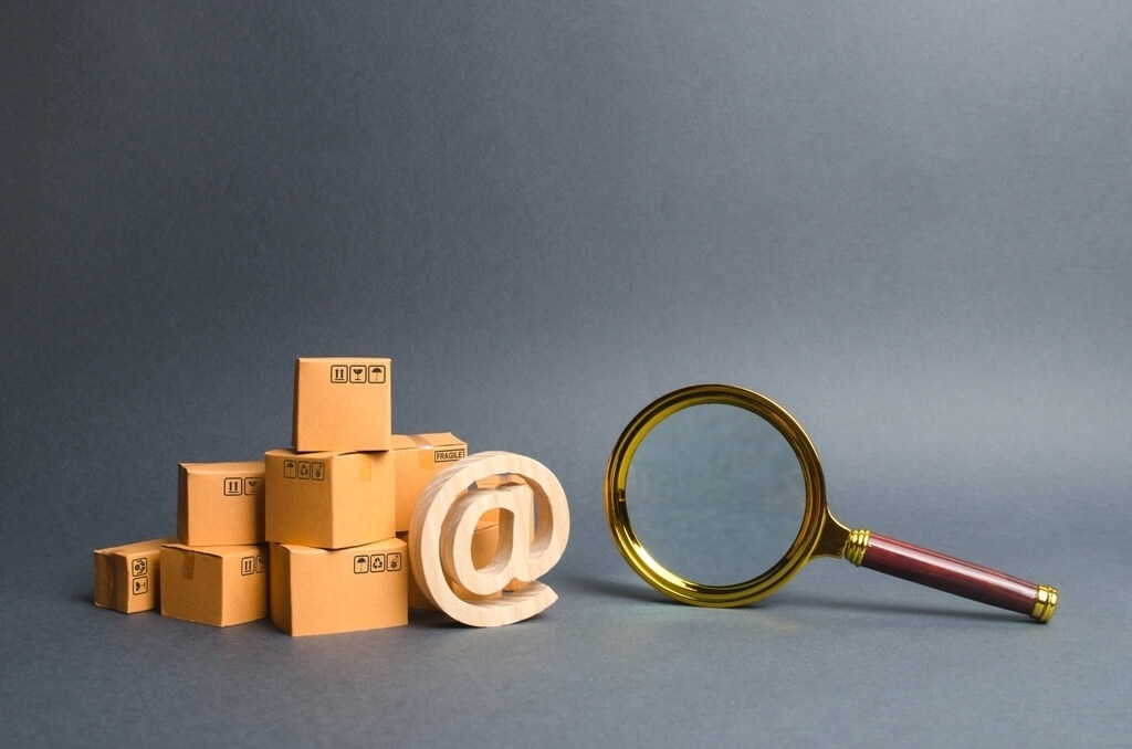 magnifying glass near pile of boxes and email sign