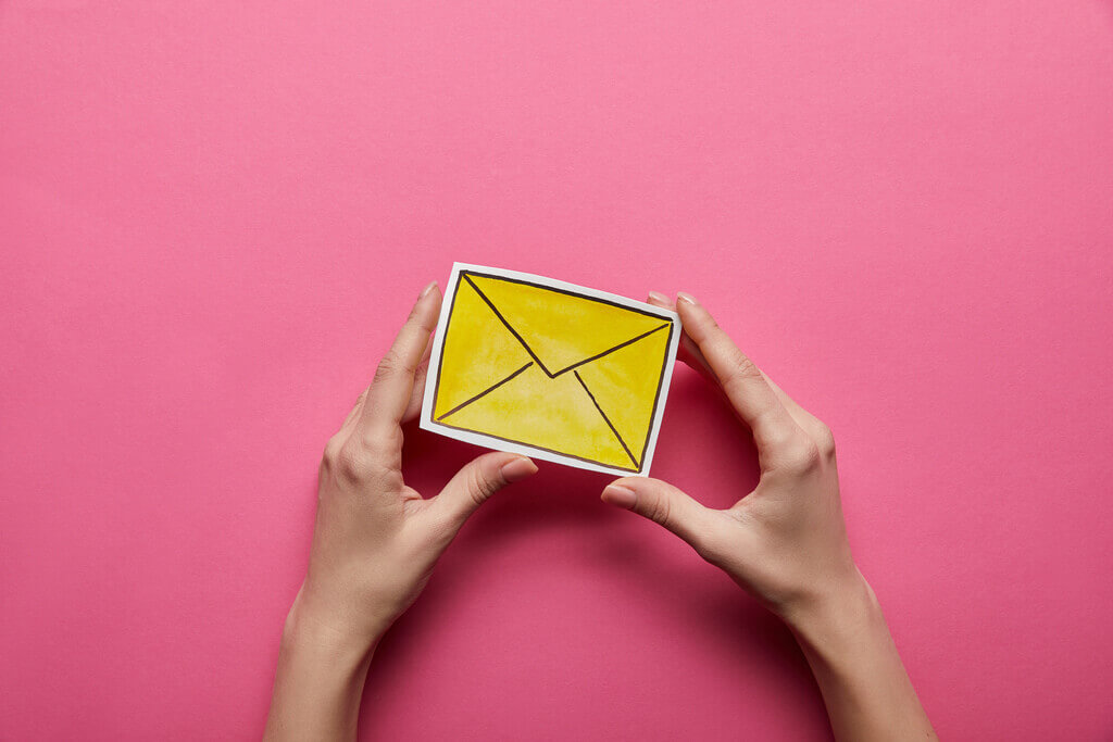 woman hands holding a yellow email symbol